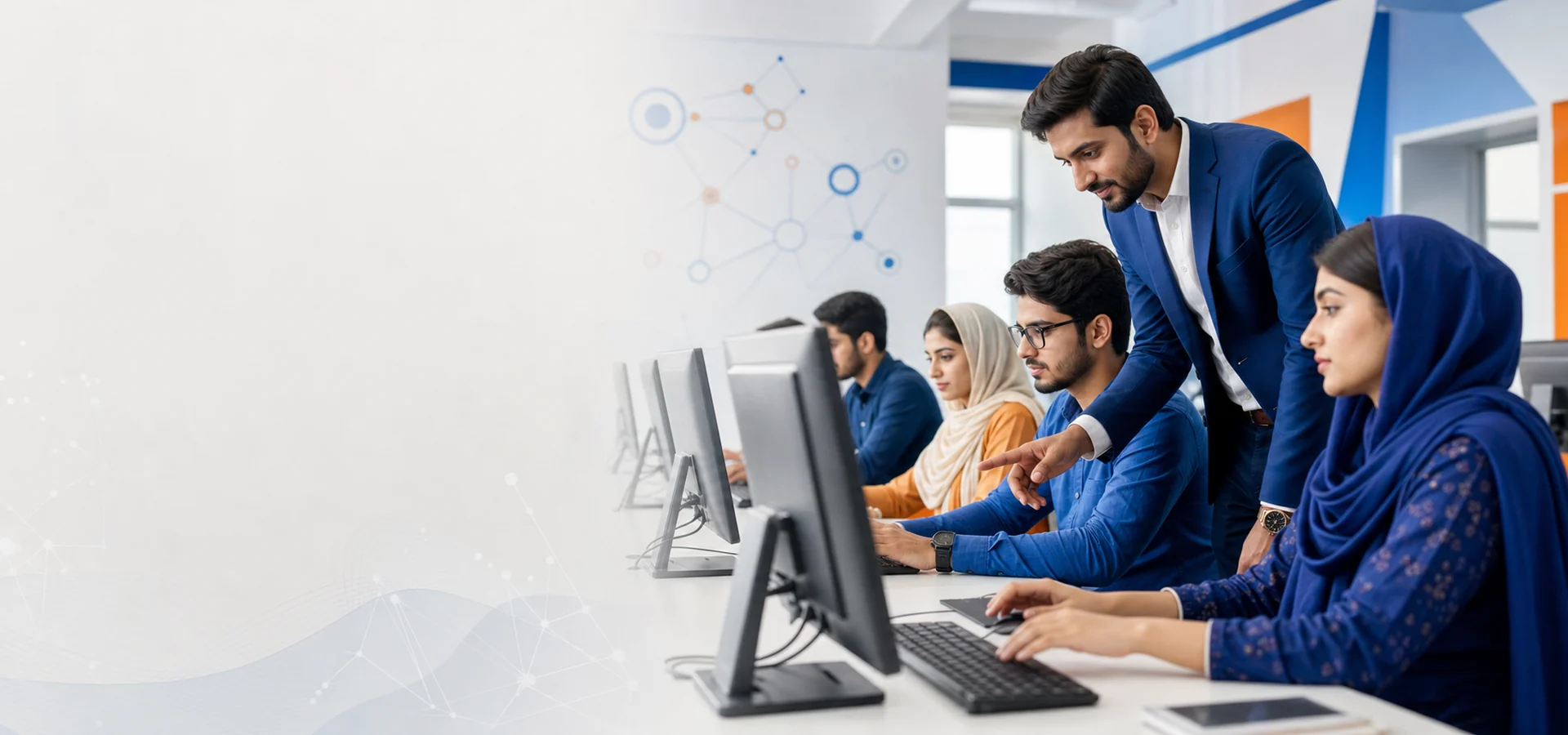 Pakistani students learning coding with an instructor in a modern computer lab